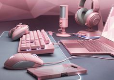 a laptop computer sitting on top of a desk next to a pink mouse and keyboard