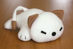 a white stuffed animal laying on top of a wooden floor