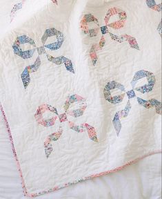 a white quilt with blue and pink bows on it