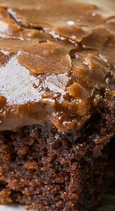 a close up of a piece of cake on a plate with frosting and caramel