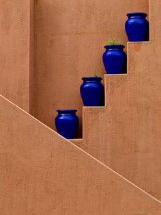 blue vases are lined up on the stairs