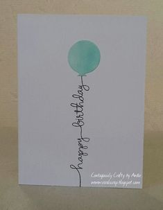 a white card with a green balloon on it's side and the words happy birthday written in cursive writing