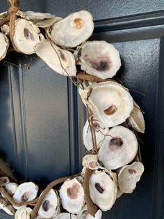 a wreath made out of seashells hangs on the front door's blue door