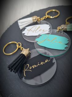 personalized acrylic keychains with tassels and name tags on them