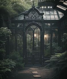 an old - fashioned glass house in the middle of a forest with lots of greenery