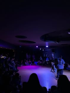 a man standing on top of a dance floor in front of a group of people