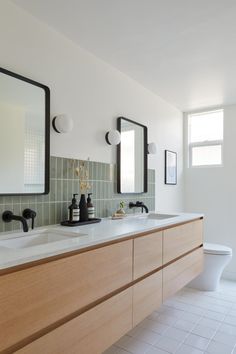 a bathroom with two sinks and mirrors on the wall