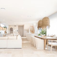 a living room filled with white furniture and lots of natural light coming through the windows