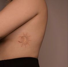 a woman's stomach with a small sun and moon tattoo on her left side