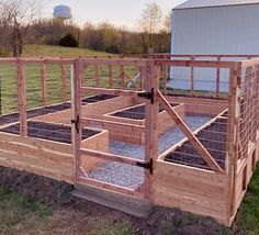 a wooden structure with several plants growing in it and on top of the fence is a barn