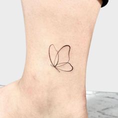 a small butterfly tattoo on the ankle