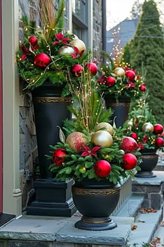 christmas decorations are lined up on the front steps in pots with greenery and baubles