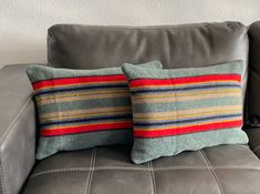 two pillows sitting on top of a gray couch