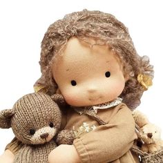 an old fashioned doll holding a teddy bear