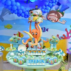 an octopus under the sea themed birthday party with cake and desserts on it's table