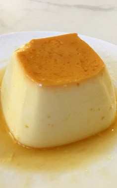 a piece of cheesecake sitting on top of a white plate covered in caramel sauce