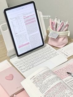 an open laptop computer sitting on top of a desk next to a notebook and pen