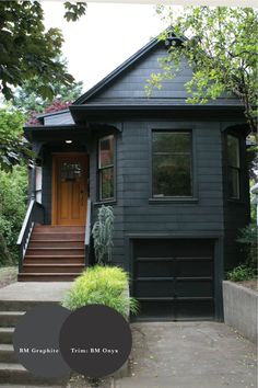 a black house with stairs leading up to the front door