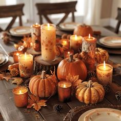 a table topped with lots of candles and pumpkins