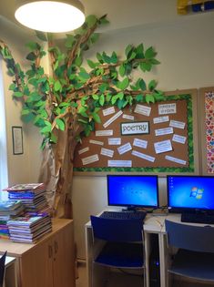 two computers sitting on top of desks under a tree