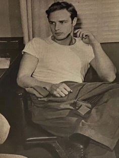 black and white photograph of man sitting in chair