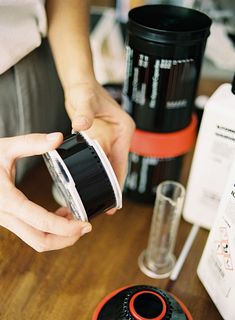 a person holding a cup over a wooden table