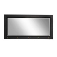 a black framed mirror with three brass knobs on the bottom and an empty shelf below it