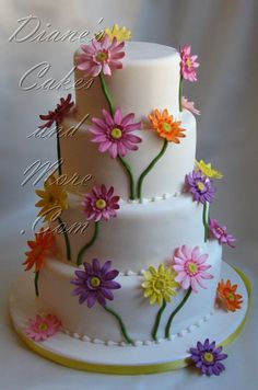 a three tiered cake decorated with colorful flowers