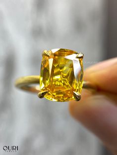 a yellow diamond is being held up to the camera