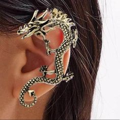 a woman wearing an ear cuff with a dragon design on it