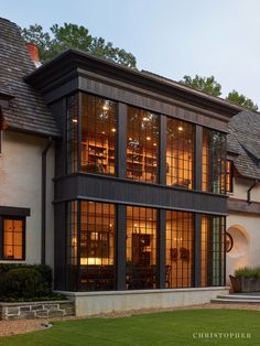 a large house with lots of windows on the front and side of it at night