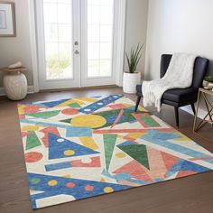 a brightly colored area rug in the middle of a living room with a chair and potted plant