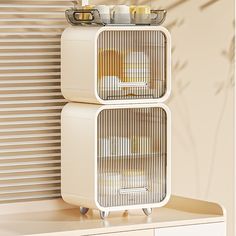 two white containers with food on them sitting on top of a shelf next to a wall