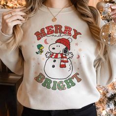 Snoopy Merry And Bright Sweatshirt, Snoopy Christmas Sweater White Casual Sweatshirt For Holidays, Casual White Sweatshirt For Holidays, White Tops With Cartoon Print For Christmas, Casual White Holiday Sweatshirt, White Cartoon Print Tops For Christmas, White Christmas Tops With Cartoon Print, Snoopy Christmas Shirt, White Christmas Cartoon Print Tops, Snoopy Embroidered Sweatshirt