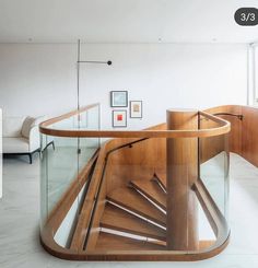 a wooden spiral staircase with glass railing