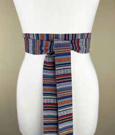 Aztec Sash, Tribal Sash  Woven Ethnic Print Sash  Native American Belt, Boho Accessories  Festival Print Waist Sash, Wrap Belt  This Satin Swank® sash in a woven Aztec fabric provides an instant update to your denim or casual look. This one easy piece is two inches wide, 94 inches long, and will wrap around most waist sizes two times with a generous length remaining to tie in a simple knot with long-hanging tails. Tie in front, in back, or on the side. SIZING/COLOR/PRINT INFO: Sash Measurements: 2" wide, 94" long (point to point) The mannequin pictured has a 28 inch waist. Fabric color intensity may vary depending on the settings of the monitor/device on which you view this item. Each sash is unique and made to order. FABRIC INFO & CARE: 100% cotton Hand wash, air dry Iron on medium  COPYR Aztec Fabric, Waist Sash, Wrap Belt, Boho Accessories, Ethnic Print, Suspender Belt, Color Print, Fabric Color, Colorful Prints