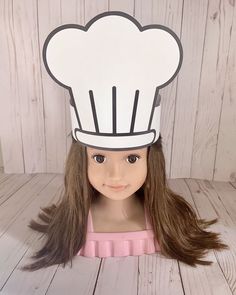 a doll wearing a chef's hat with long brown hair