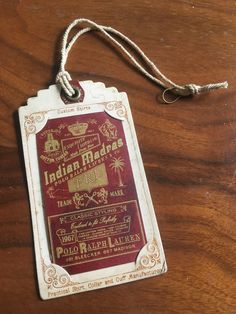 a red and white luggage tag sitting on top of a wooden table next to a string