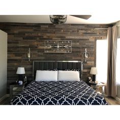 a bedroom with wood paneling and white pillows