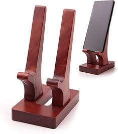 two wooden cell phones on stands with one phone in the other's holder and another holding an electronic device