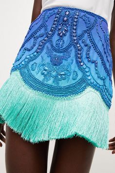 Borrowing From The Art Deco Era, This Opulently Beaded Ombre Mini Skirt Blends Swishy Tassels With A High-Rise Fit And Undeniably Glamorous Vibe. The Tassels Come Cut In A Draped, Asymmetric Line, Giving This High-Voltage Piece A Beautiful Sense Of Movement.Style: Skirtdesign: Embroideredfabric: Wovenlength: Mini Beaded Fringe Skirt, Fringe On Clothes, Beaded Mini Skirt, Bohemian Party Bottoms With Tassels, Spring Party Mini Skirt With Rhinestone Fringe, Summer Embellished Blue Skirt, Embellished Blue Skirt For Summer, Elegant Summer Skirt With Tassels, Summer Blue Embellished Skirt