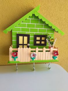 a house made out of wood with flowers on the fence