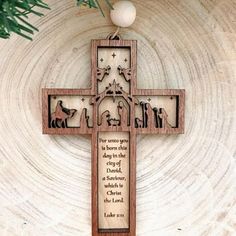 a wooden cross hanging on the wall with an ornament in front of it