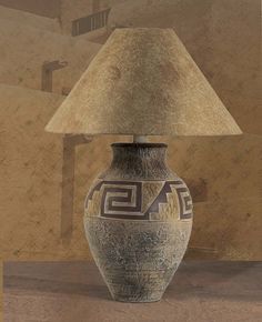 a lamp sitting on top of a wooden table next to a vase with a design on it