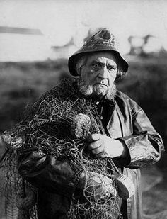 an old man is holding some kind of netted object in his hands and looking at the camera