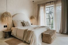 a bedroom with a large bed and two wicker baskets on the floor next to it