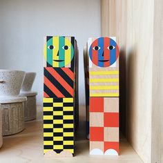 two wooden blocks with faces and stripes on them