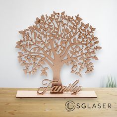 a wooden family tree with the word family carved into it's base on a table