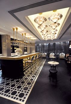 the bar is decorated in black and white with chandeliers hanging from the ceiling