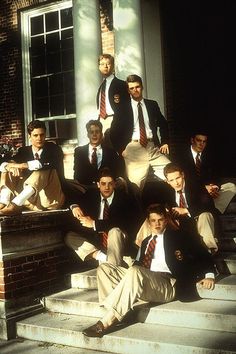 a group of men in suits and ties sitting on steps